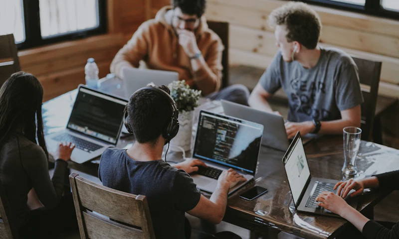 A team working together on laptops around a shared table